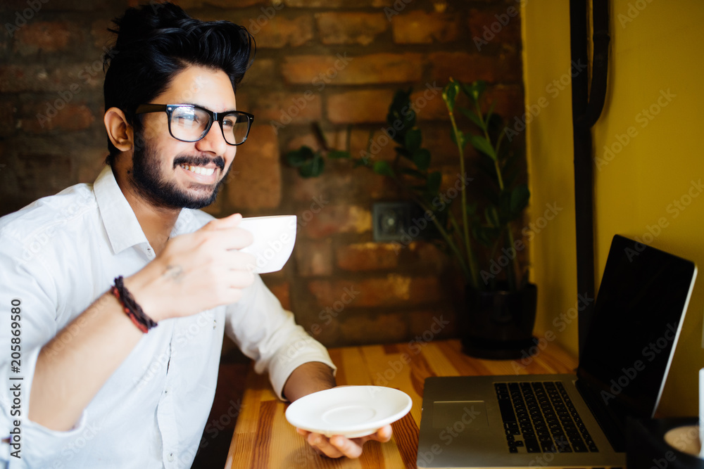 Young indian man having coffee at cafe shop Young indian man having coffee at cafe shop