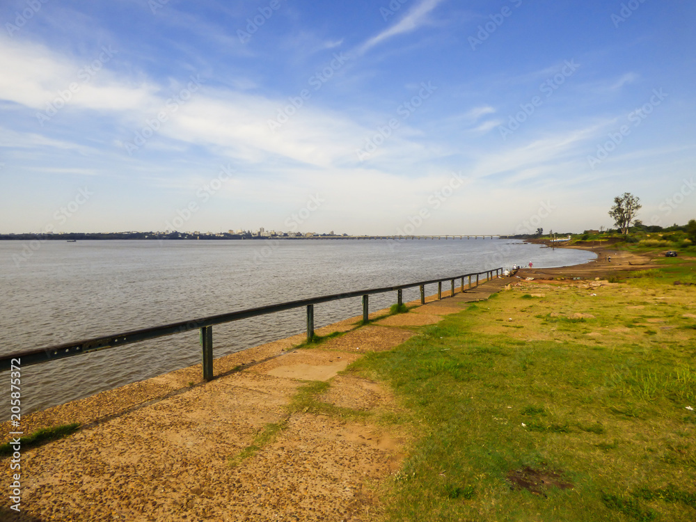 Obraz premium A view of the Costanera (Park by the Uruguay river) in Paso de los Libres, Argentina - the Brazilian city of Uruguaiana is seen in the background