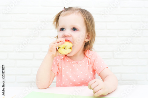 Cute little 2 years girl eats apple