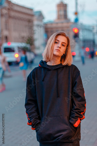 portrait of a beautiful young blonde girl in a night city