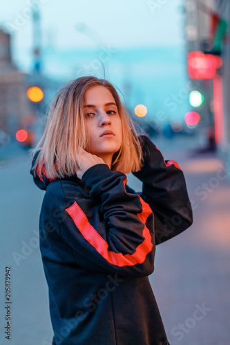 portrait of a beautiful young blonde girl in a night city