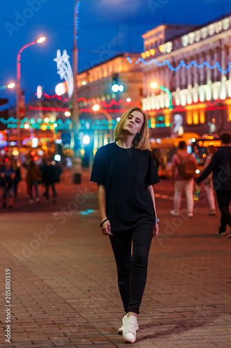 portrait of a beautiful young blonde girl in a night city