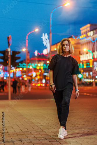 portrait of a beautiful young blonde girl in a night city