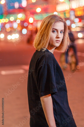 portrait of a beautiful young blonde girl in a night city