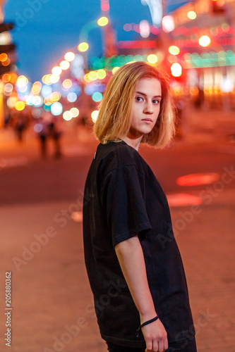 portrait of a beautiful young blonde girl in a night city
