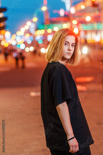 portrait of a beautiful young blonde girl in a night city