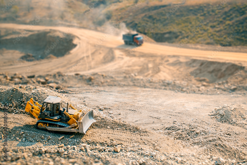 The bulldozer moves and spreads the soil and rubble on the embankment of the road.Work bulldozer on the construction of a highway.. Road under construction. The bulldozer moves and spreads the soil and rubble on the embankment of the road.Work bulldozer on the construction of a highway.. Road under construction.