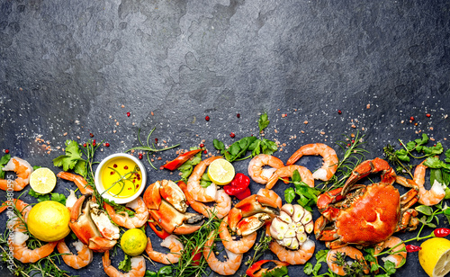 Canvas Print Fresh raw seafood - shrimps and crabs with herbs and spices on dark gray background