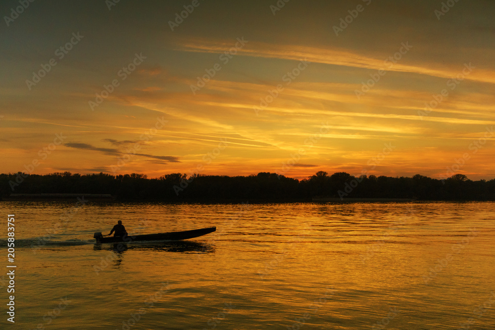 Lonely fisherman in romantic sunset