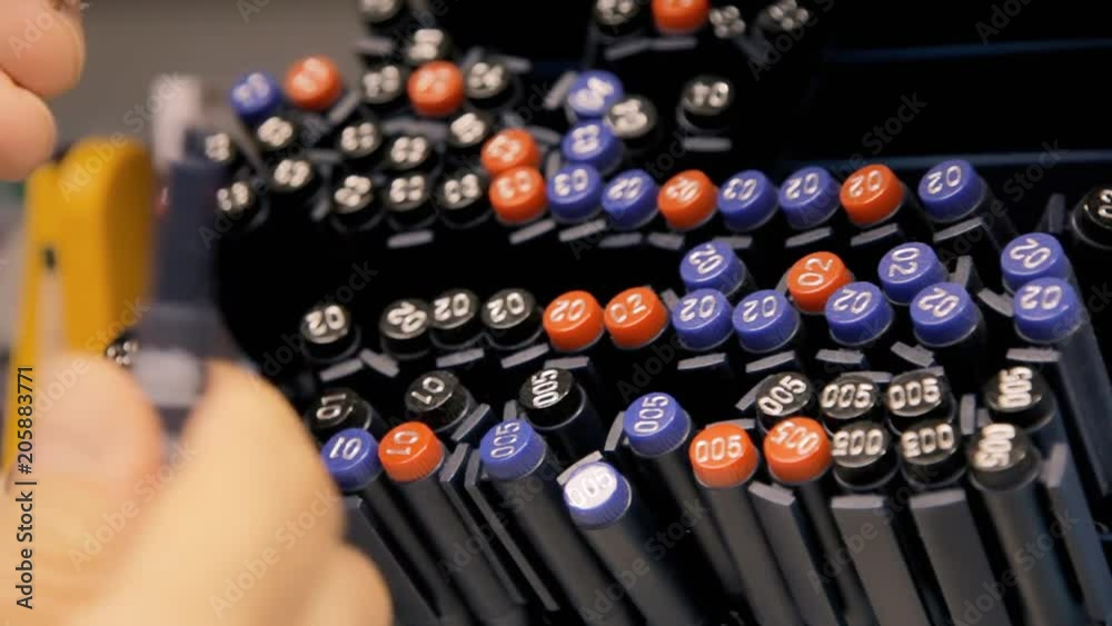 The hands of a customer choosing fine art pens from a shelf in a stationery shop. Angled close-up detail shot.
The hands of a customer choosing fine art pens from a shelf in a stationery shop. Angled close-up detail shot.