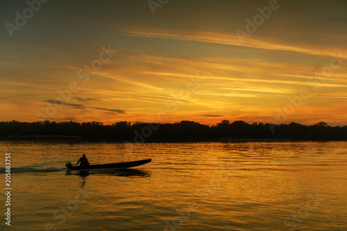 Lonely fisherman in romantic sunset