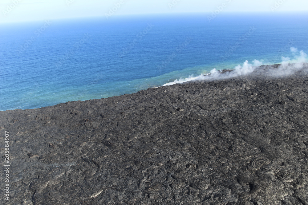 Helicopter aerial view of lava entering the ocean and steam, Big Island, Hawaii. Helicopter aerial view of lava entering the ocean and steam, Big Island, Hawaii.