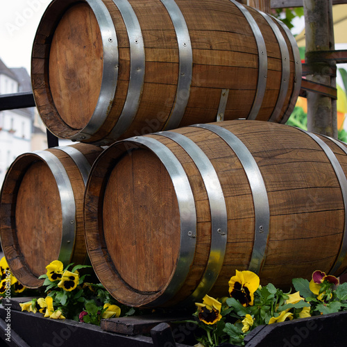 Three wine barrels decor with viola flowers.