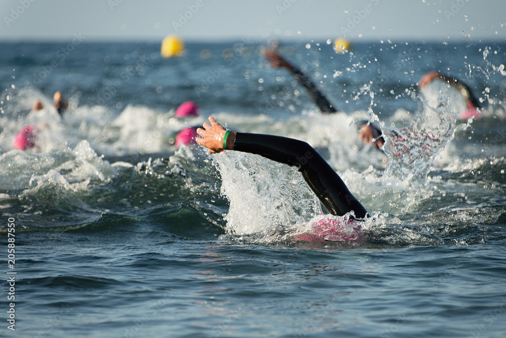 Group people in wetsuit swimming at triathlon