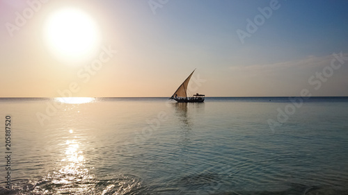 Zanzibar traditional Dhow boat sailing in the sea at sunset