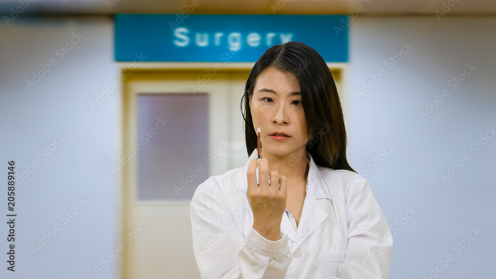 Asian doctor in hospital holding syringe Asian doctor in hospital holding syringe
