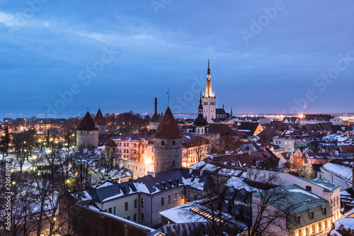 Twilight over the Tallinn old town cityscape with the Saint Olaf church and the medieval fortified wall in Estonia capital city.