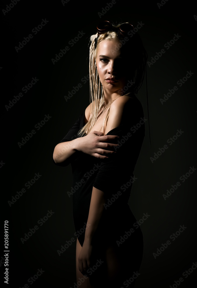 sexy blonde woman with dreadlocks and welding glasses on a dark background in the studio