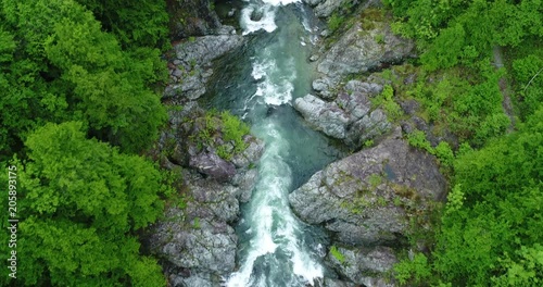 Aerial view of a mountain river flowing between rocks and forests in spring. River Sesia in Valsesia, Piedmont, Italy.