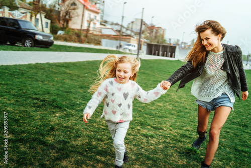 Mother with her little daughter have fun in the park