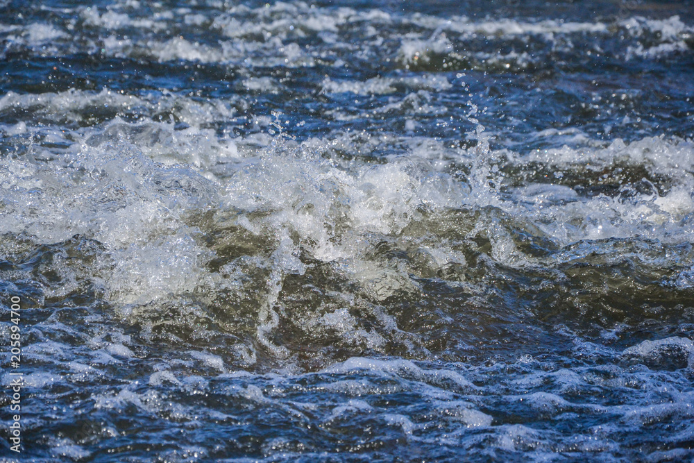 Splash of waves from a waterfall on a clear spring day