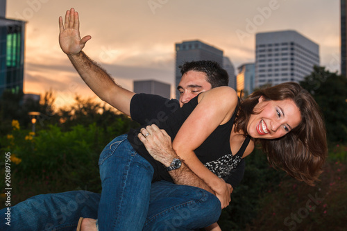 Young couple outdoor portrait having fun in a downtown urban park photo