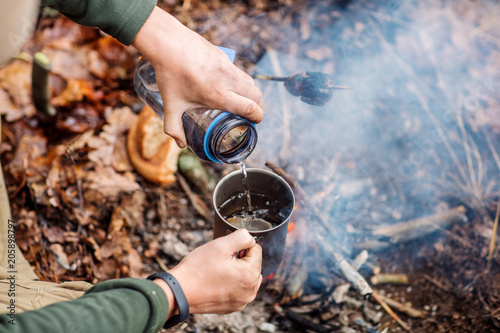 Wallpaper Mural hunter pours water from a bottle into a metal mug. Torontodigital.ca