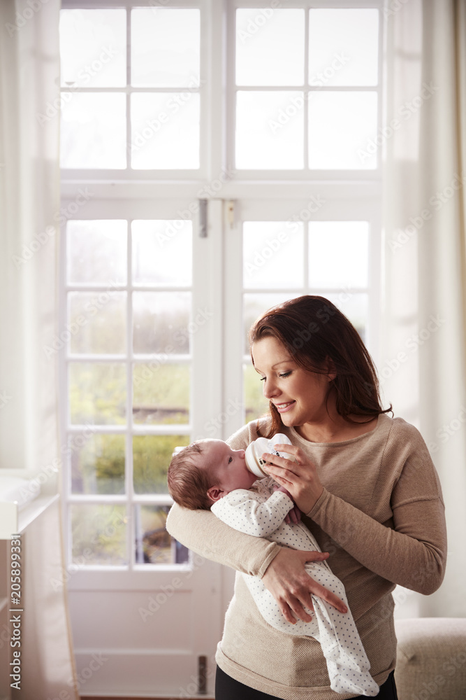 Mother Feeding Newborn Baby From Bottle At Home Mother Feeding Newborn Baby From Bottle At Home