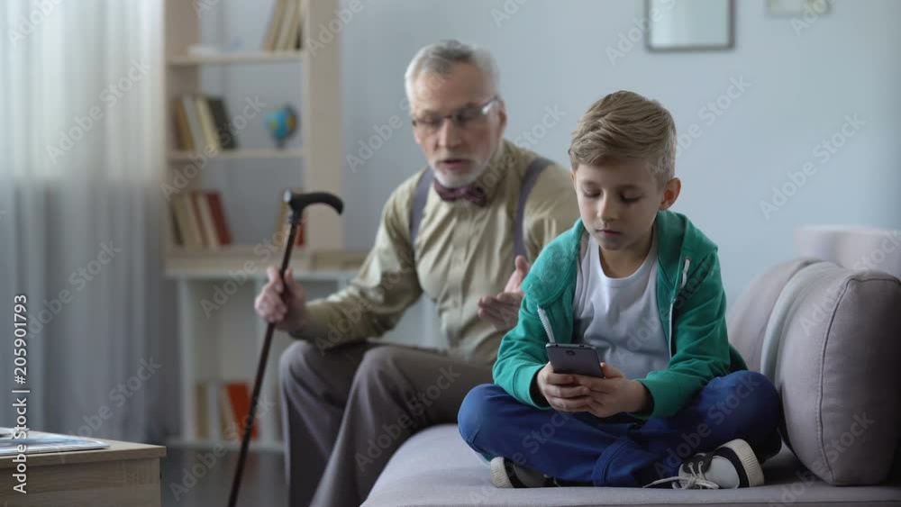 Upset grandfather scolding grandson for using cell phone, internet addiction Upset grandfather scolding grandson for using cell phone, internet addiction