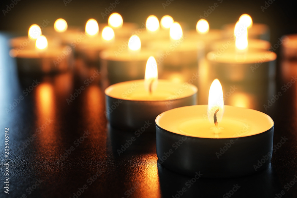 Wax candles burning on table in darkness, closeup Wax candles burning on table in darkness, closeup