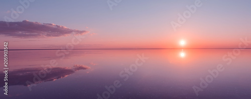 Landscape beautiful golden sunset red sky solt lake saline Elton Baskunchak. The sun sets behind the horizon photo