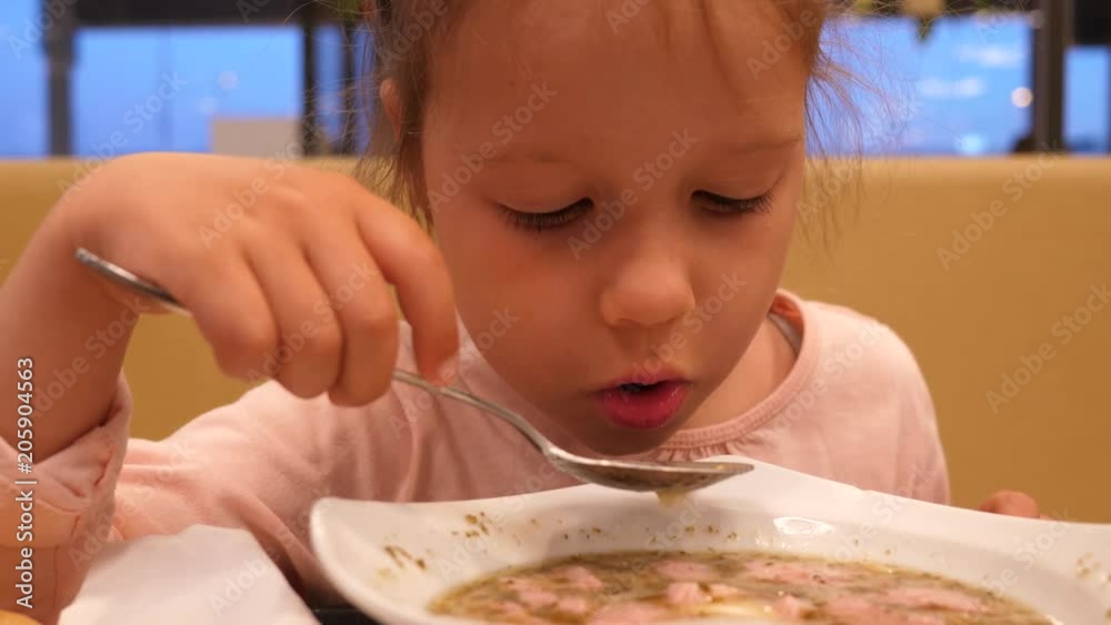 Petrol station food court child girl daughter portrait eating a soup with a spoon Petrol station food court child girl daughter portrait eating a soup with a spoon