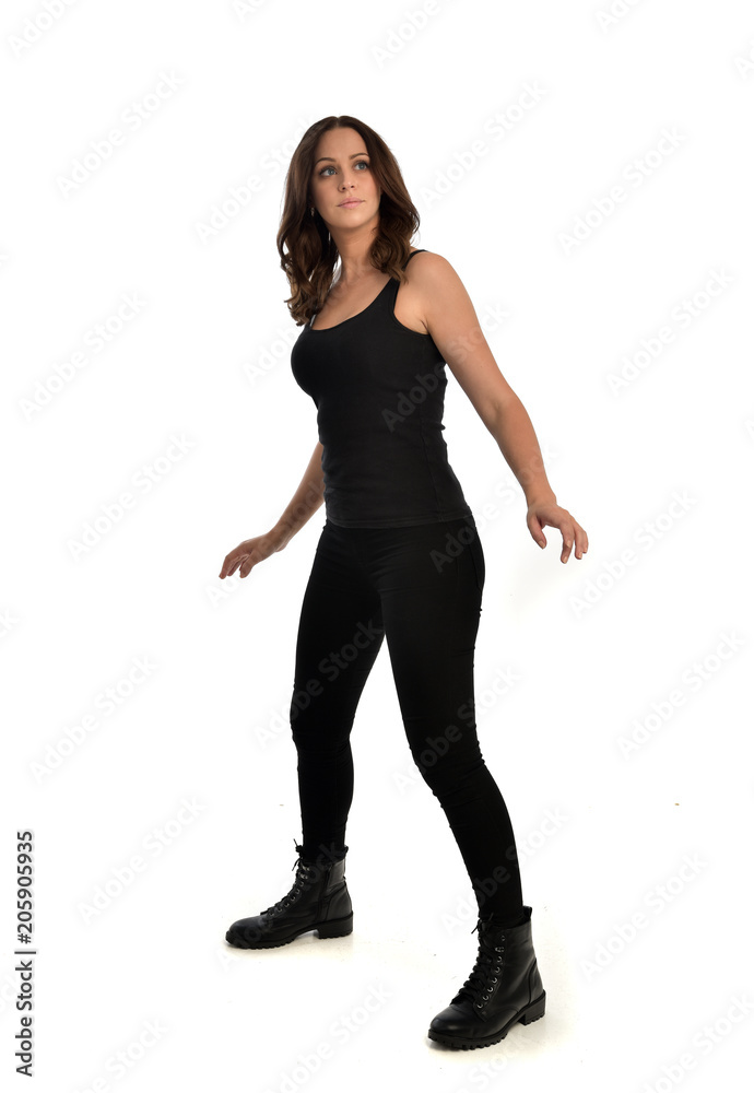 full length portrait of brunette girl wearing black singlet, jeans jeans and boots. standing pose, isolated on white studio background. full length portrait of brunette girl wearing black singlet, jeans jeans and boots. standing pose, isolated on white studio background.