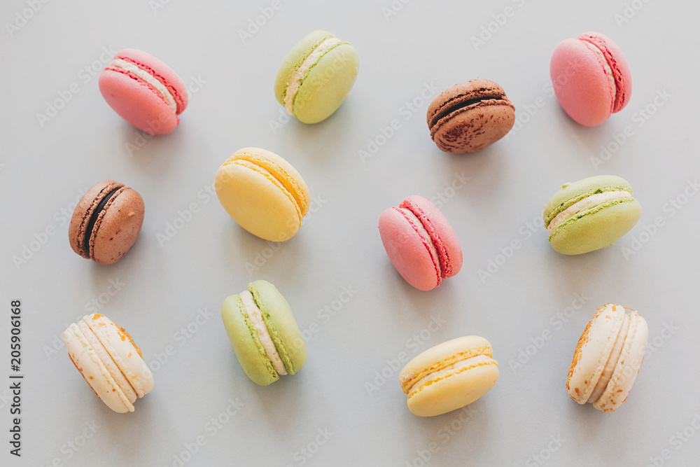 delicious colorful macaroons on trendy pastel gray paper flat lay. tasty pink, yellow, green and brown macaroons pattern. space for text. candy for party. yummy background delicious colorful macaroons on trendy pastel gray paper flat lay. tasty pink, yellow, green and brown macaroons pattern. space for text. candy for party. yummy background