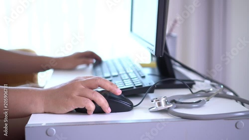 Healthcare and medical concept: Medicine doctor's working and using mouse on laptop computer with Stethoscope on table workplace in hospital, Focus on stethoscope