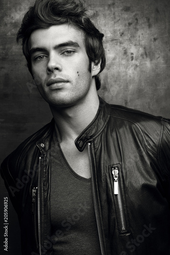 Stylish young man in black leather jacket. Contrast black and white portrait