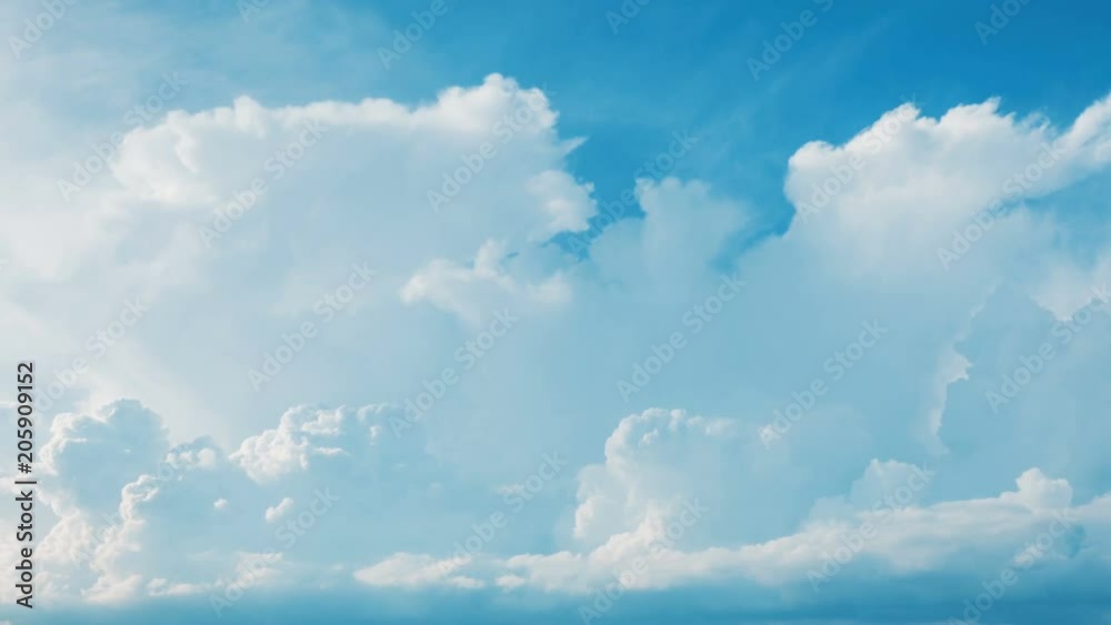 Time lapse white fluffy cumulus clouds flying, fast moving blue sky at cloudy summer day