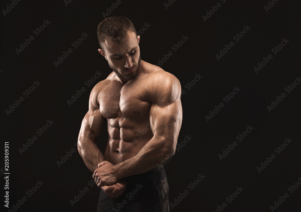 Strong athletic man showes naked muscular body Strong athletic man showes naked muscular body