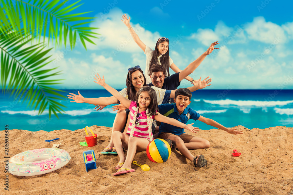 Happy Indian/Asian family playing at the beach. Summer vacation concept ...