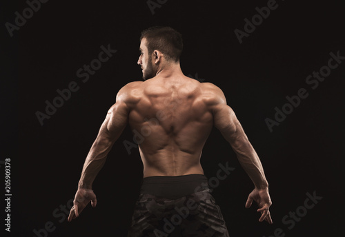 Unrecognizable man shows strong back muscles closeup