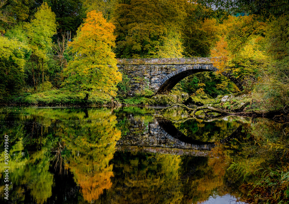 bridge and river with autumn reflections from trees bridge and river with autumn reflections from trees