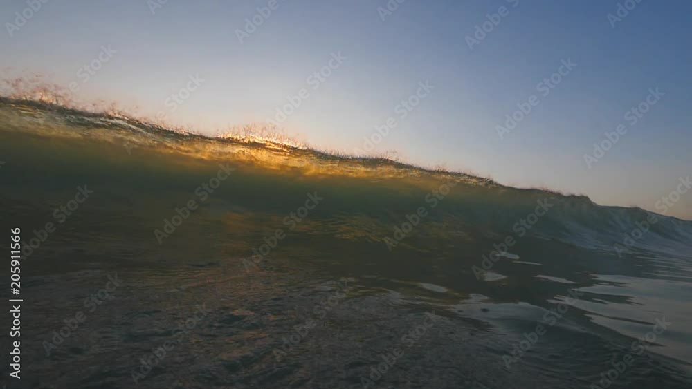 Slow motion shot of sunset surfing wave in Indonesia at Bali island