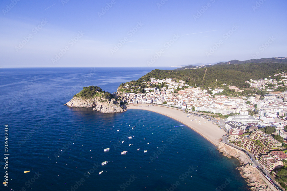 Aerial view of picturesque rocky landscape with fortified walls and residential buildings of Tossa de Mar, Spain