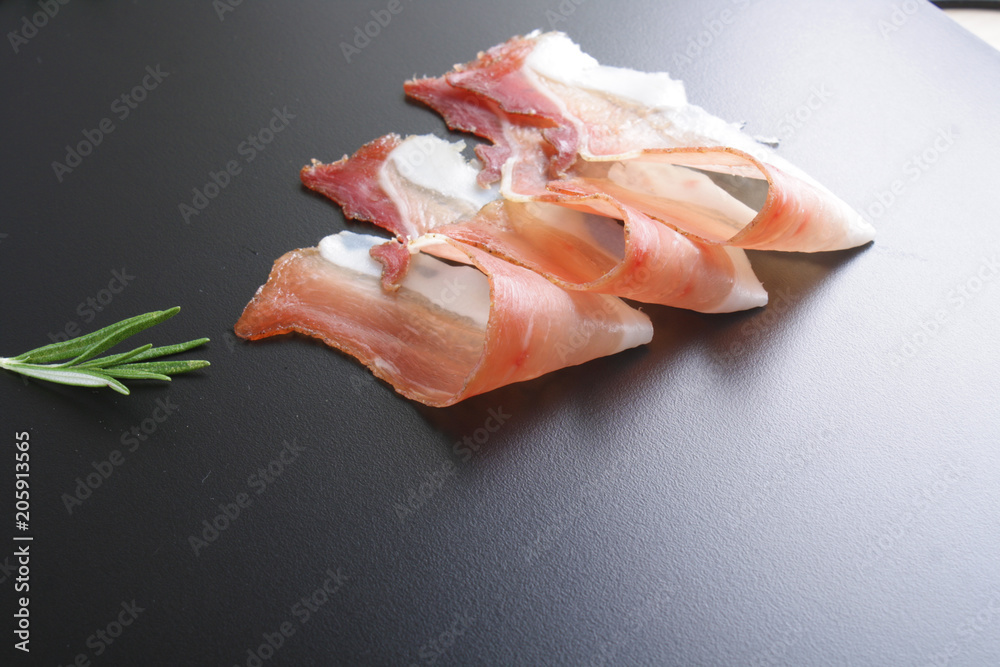 prosciutto, jamon on a black background