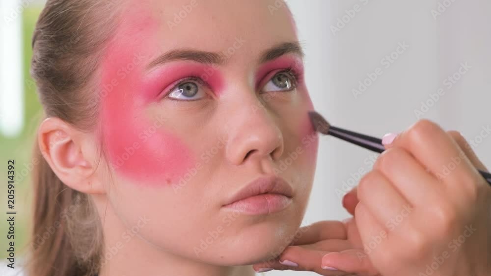 Close-up macro on eyes, making colorful eyeshadows creative makeup tutorial. Make-up artist applying creative maquillage at beauty class on a beautiful model girl's face. Close-up macro on eyes, making colorful eyeshadows creative makeup tutorial. Make-up artist applying creative maquillage at beauty class on a beautiful model girl's face.