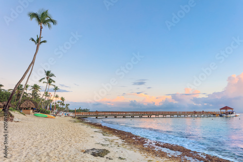 Sunset beach of La Romana, Dominican Republic with long wooden pier