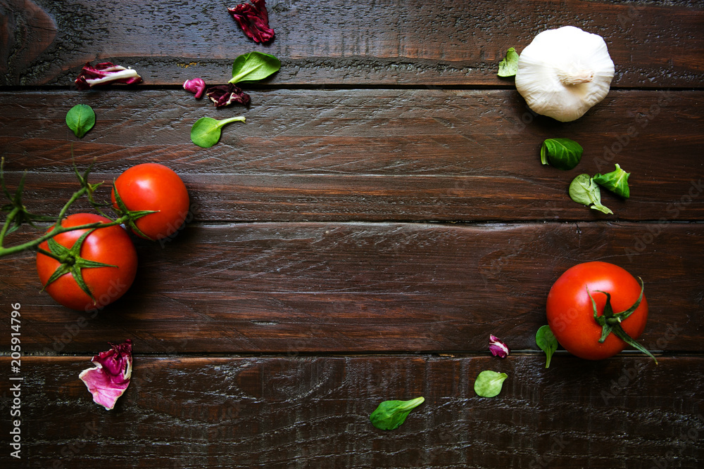 Dark wooden background with tomatoes and garlic, with space for text. Flat lay, top view Dark wooden background with tomatoes and garlic, with space for text. Flat lay, top view