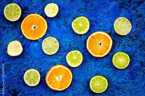 Fruit pattern. Oranges and lime round slices composition on blue background top view
