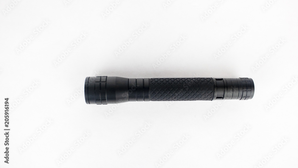 A black flashlight on an isolated white background A black flashlight on an isolated white background