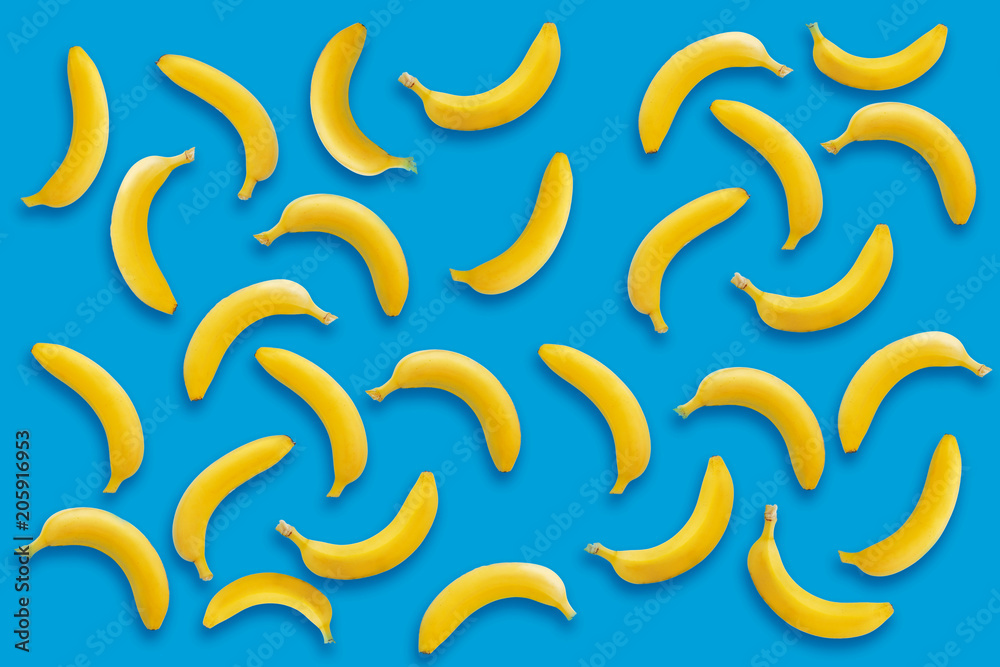 banana pattern. yellow bananas on blue paper background, trendy flat lay. summer concept